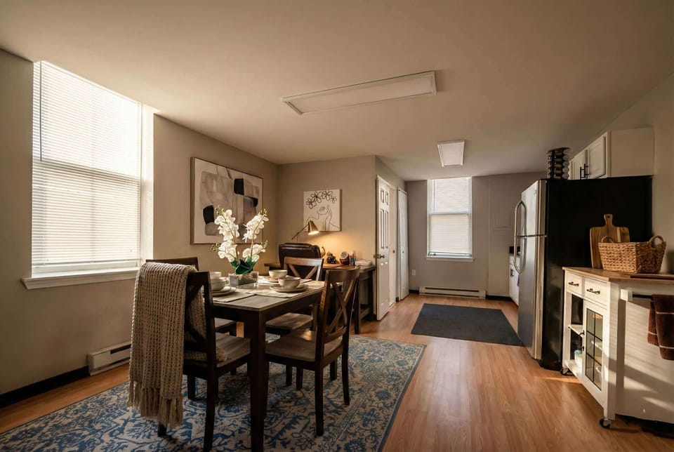 Dining area beside the kitchenette with table seating, desk, and natural light.