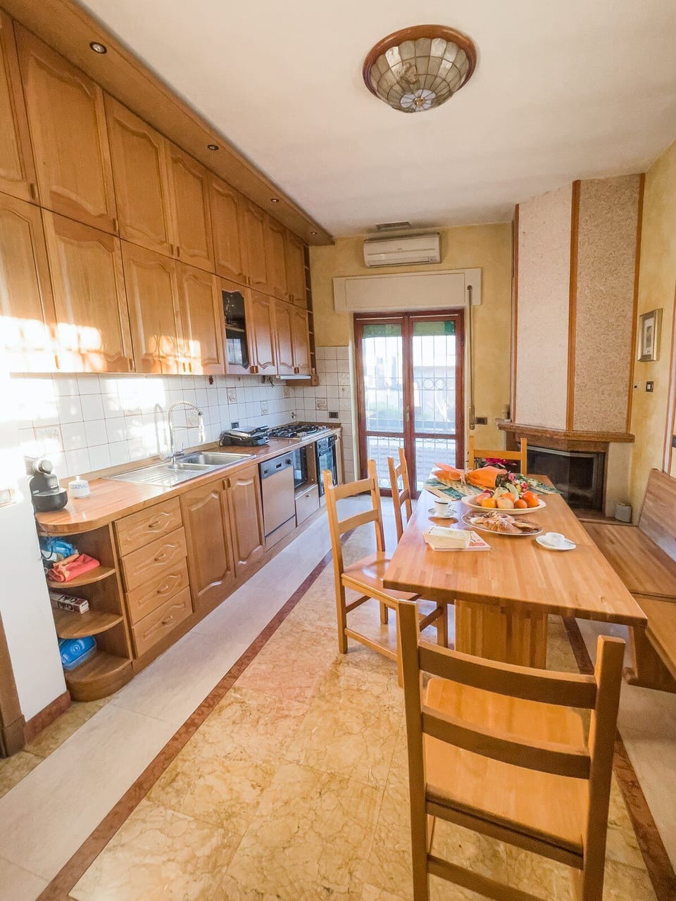 Solid wood table, fireplace, and a full kitchen.