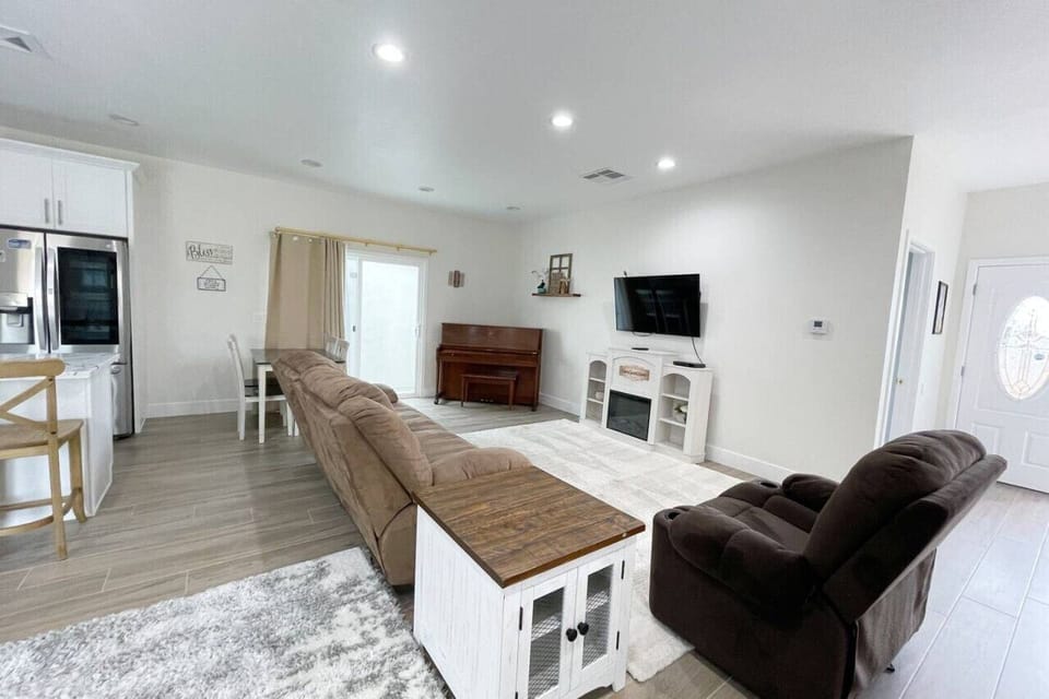 Living room just off of kitchen with comfortable seating with faux fireplace.