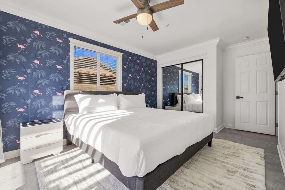 Comfortable bedroom w/ soft linens, patterned accent wall & a calm, restful vibe.