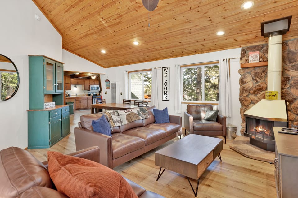 Cozy mountain living room with a fireplace, comfy seating, and smart TV—perfect for relaxing evenings, movie nights, and warm cabin vibes after outdoor adventures.