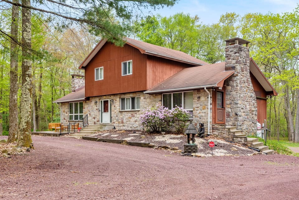 A charming cabin tucked among tall trees, blending rustic stone and wood elements for the ultimate mountain escape. A peaceful getaway with nature all around.