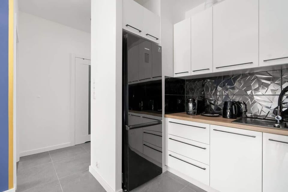 A luxurious kitchen with black marble backsplash and white cabinetry, giving a sleek and sophisticated look.
