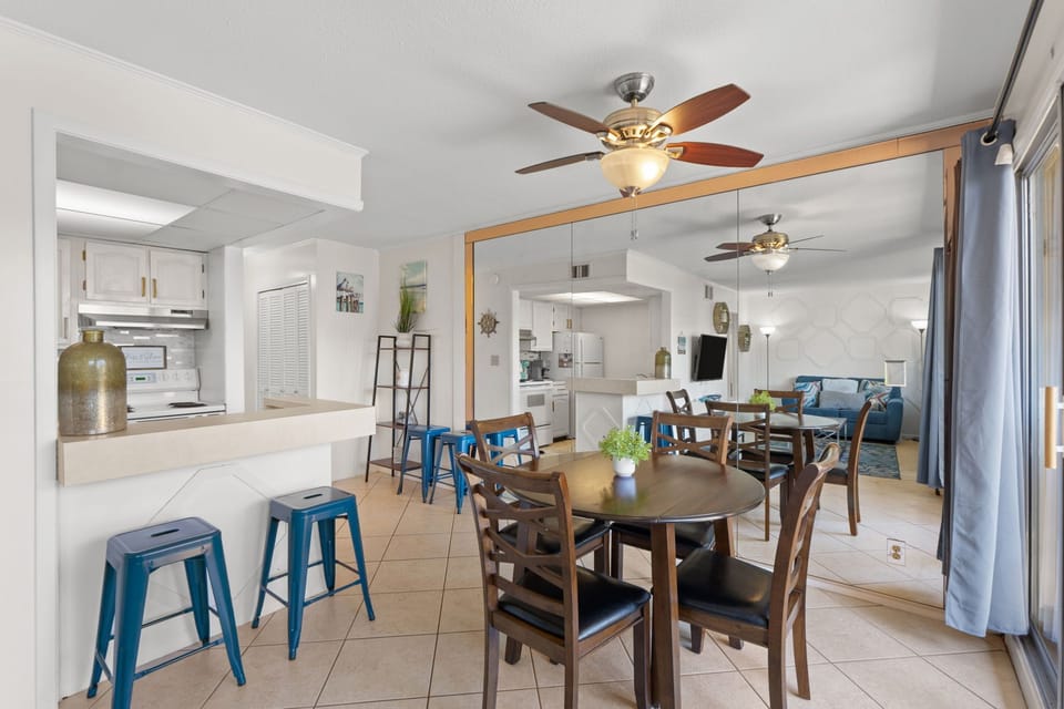 Gather around the spacious dining table where shared meals and laughter fill the air. The open-concept design flows effortlessly into your fully equipped kitchen and cozy living area, creating a welcoming heart for your stay.