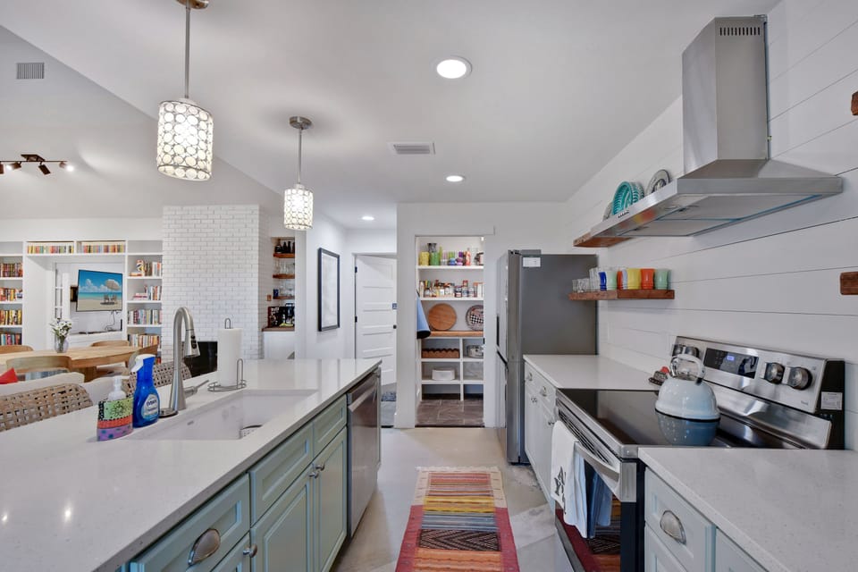 Kitchen Perspective with Pantry Shelves - This angle shows the open shelves, range hood, island, and sightline into the living room.