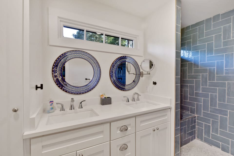 Flower Room Ensuite Bath - Double vanity, round mirrors, and walk-in shower sit inside the king suite layout.