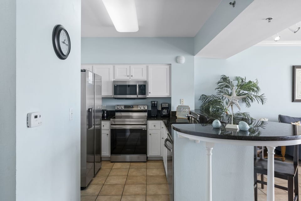 Modern kitchen with stainless steel appliances and a curved breakfast bar