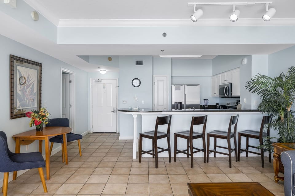 Open kitchen with a breakfast bar and seating for four in a modern, light-filled space.