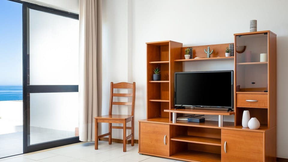 Relax with entertainment options, all while enjoying glimpses of the sparkling sea through the window.
#LivingRoom #Entertainment #LovelyStay