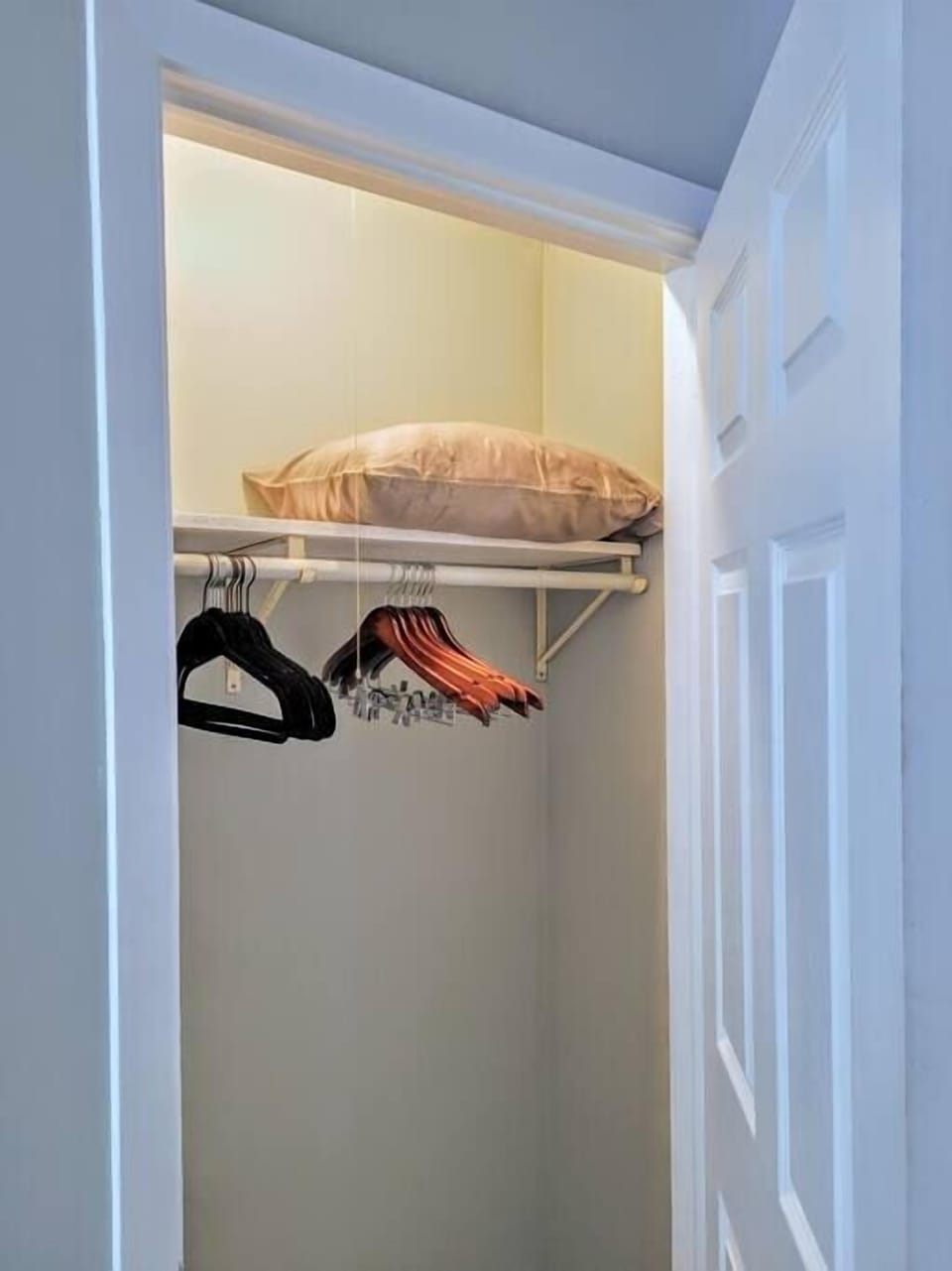 Closet spaces have an extra pillow and blanket, felt hangers, and high quality wood coat hangers