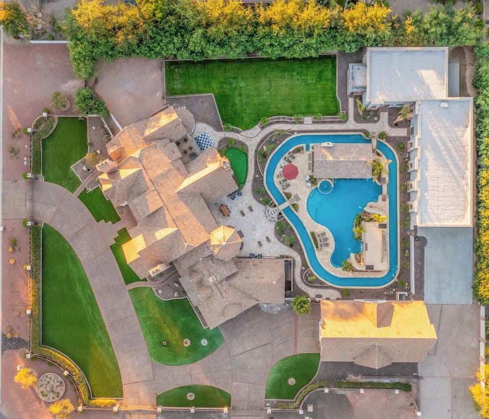 Expansive estate layout with resort-style pool, lush green lawns, and multiple entertaining spaces.