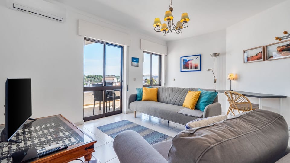 Bright and airy living space with modern décor, comfortable seating, and direct access to the balcony for seamless indoor-outdoor living. #livingroomdesign #naturallight #holidayhome #cozyspace