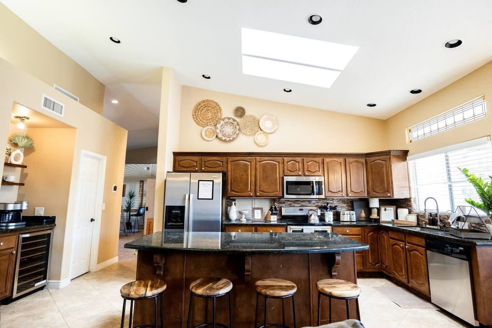 Large open concept kitchen and wine fridge are with a coffee station. 
