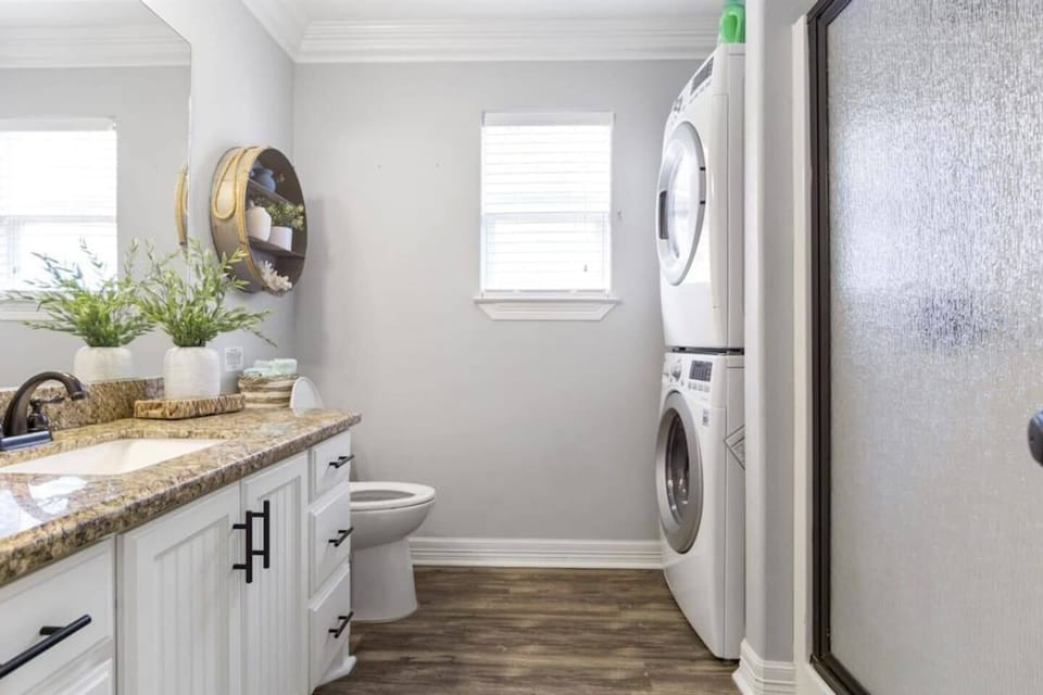a serene laundry nook with sleek appliances, nestled beside a bright, modern half-bath.