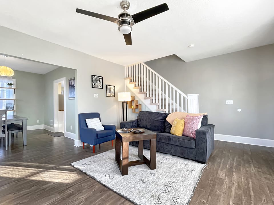 Spacious living area with open floor plan to dining room and stairs