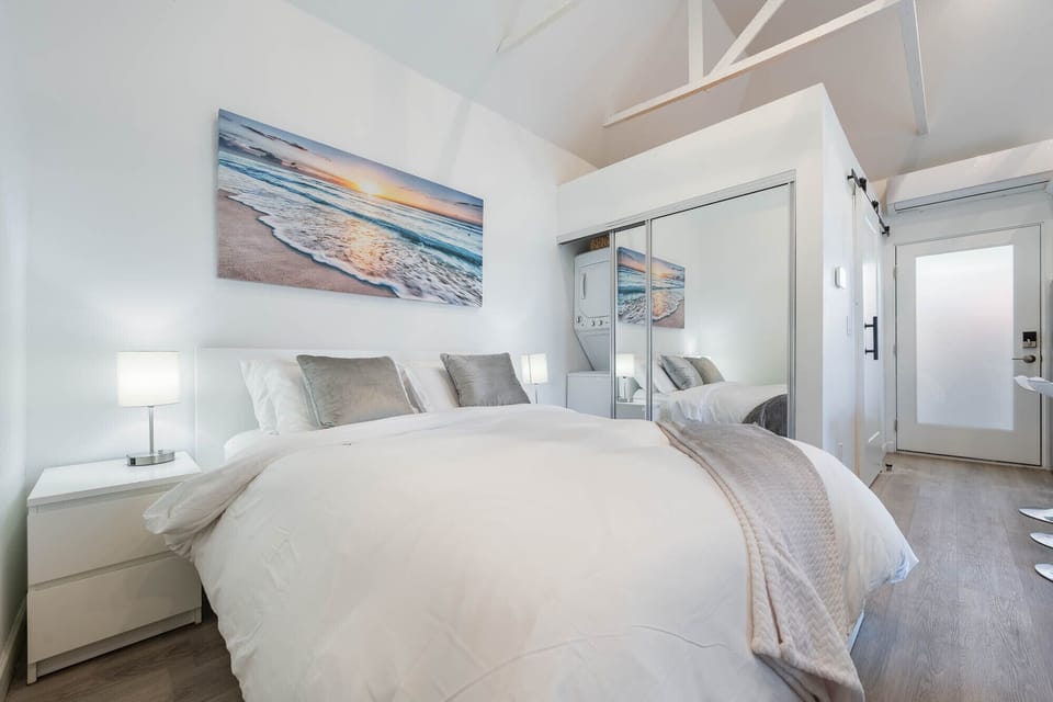 Bedroom area with queen size bed and w/d in the closet