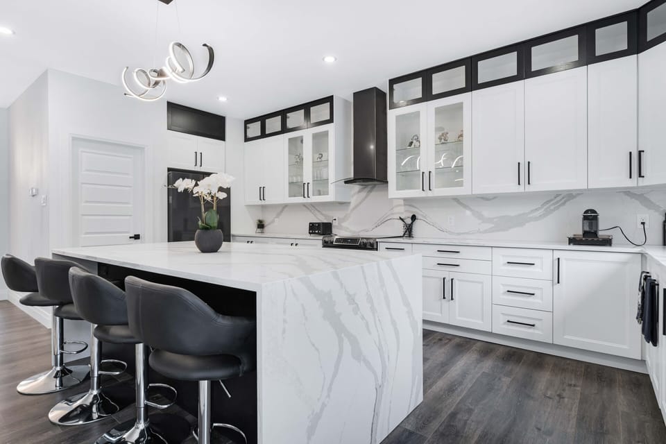 Sleek & modern kitchen featuring high end appliances & a spacious quartz island