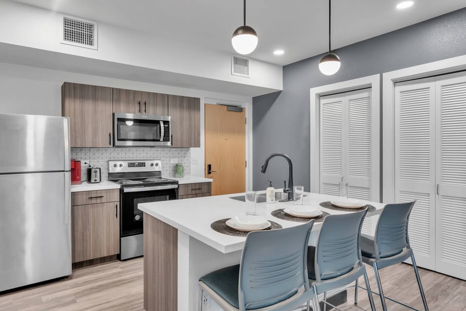 The kitchen area also has a stackable washer/dryer stored behind the luvered doors.