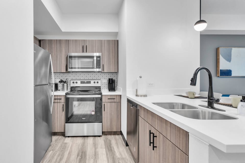 Kitchen area with all stainless steel appliances - microwave, dishwasher, range & refrigerator!