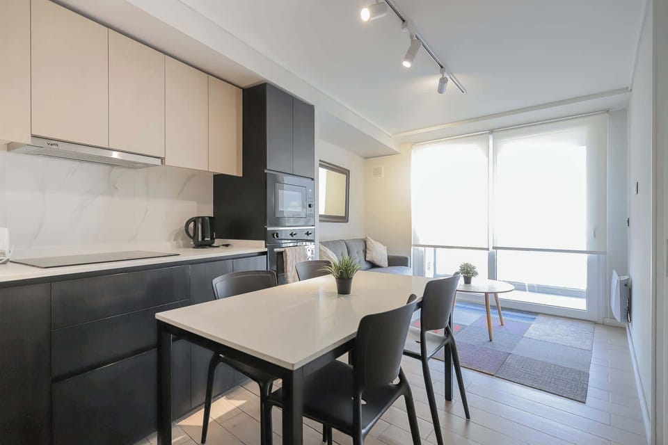 Modern studio with a sleek kitchen and cozy living area, perfect for a comfortable stay in the heart of Chile.