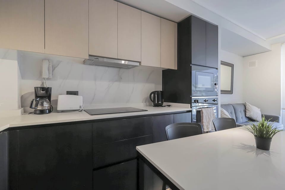 Sleek and modern kitchen with all essentials for a cozy stay, perfect for cooking and dining in style.
