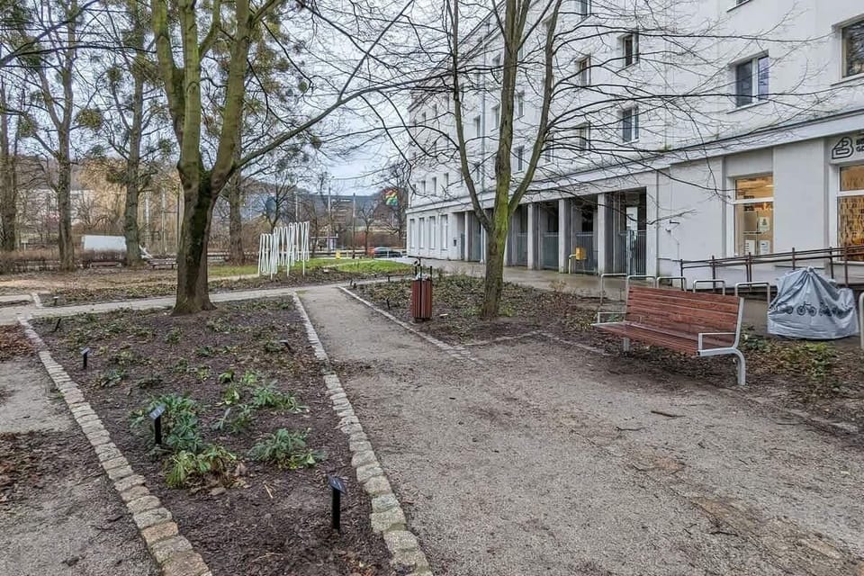 Courtyard area with benches, trees, and garden paths, promoting relaxation and outdoor enjoyment.

