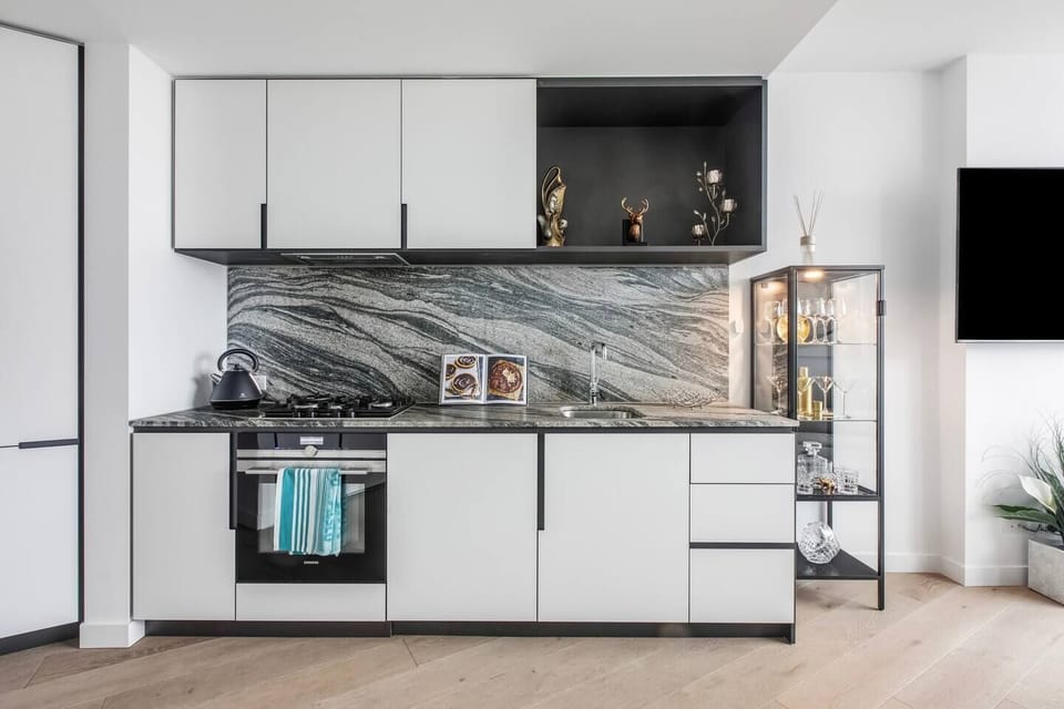 The compact kitchen makes it easy to prepare meals at home with sleek appliances and cooking utensils.
