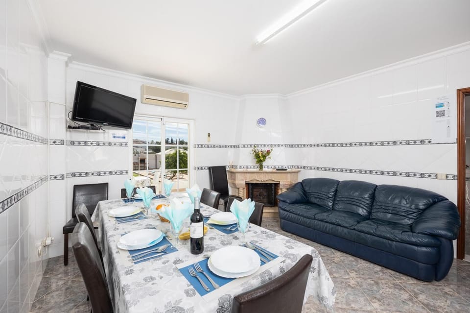 Dining area with sofa, ornamental fireplace, A/C, and TV