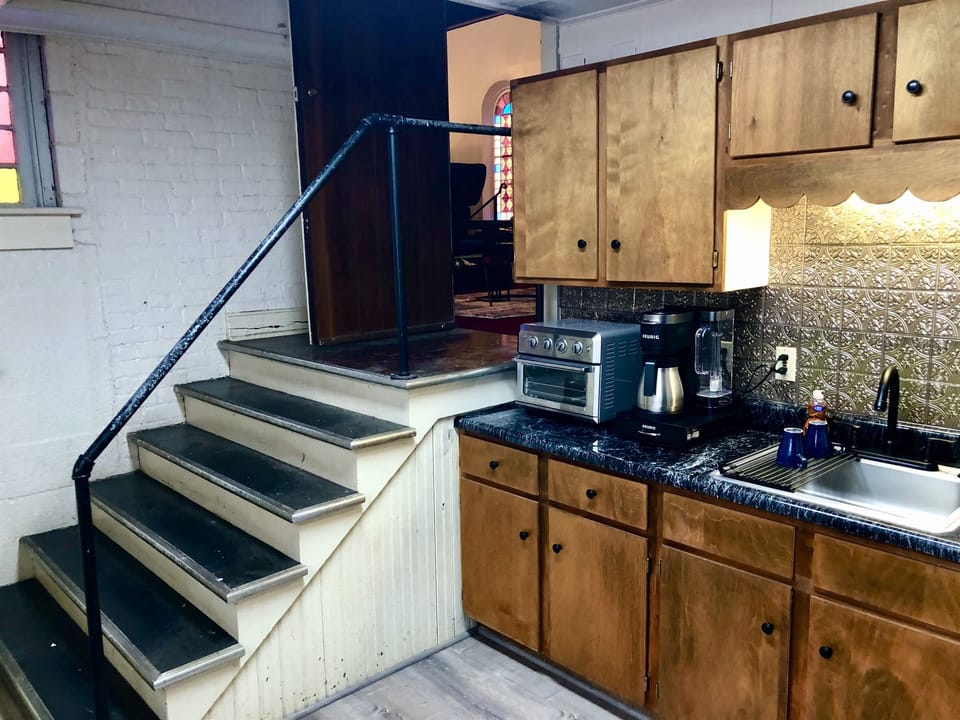 The kitchen is tucked to the side of the main sanctuary, just down a short set of wide steps and just off the sitting area with its television and electric fireplace for relaxing.  When you're relaxing, a snack or a cup of hot cocoa are just steps away.