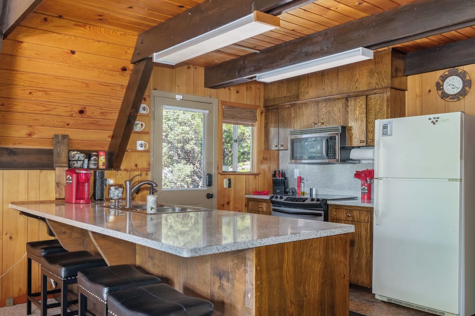 Open kitchen connects to living room. Bar with 4 stools promotes sociability.