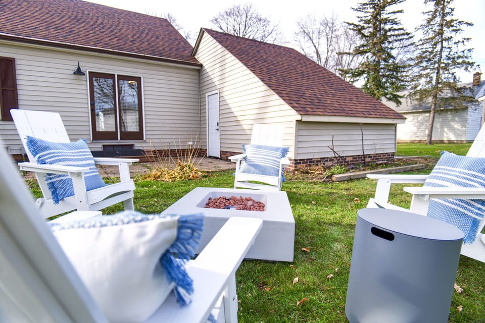 Patio in the backyard with 4 adirondack chair and fire pit