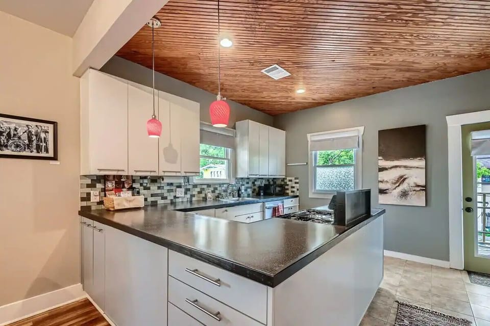 Upper level kitchen, fully stocked, with door to upper deck overlooking backyard