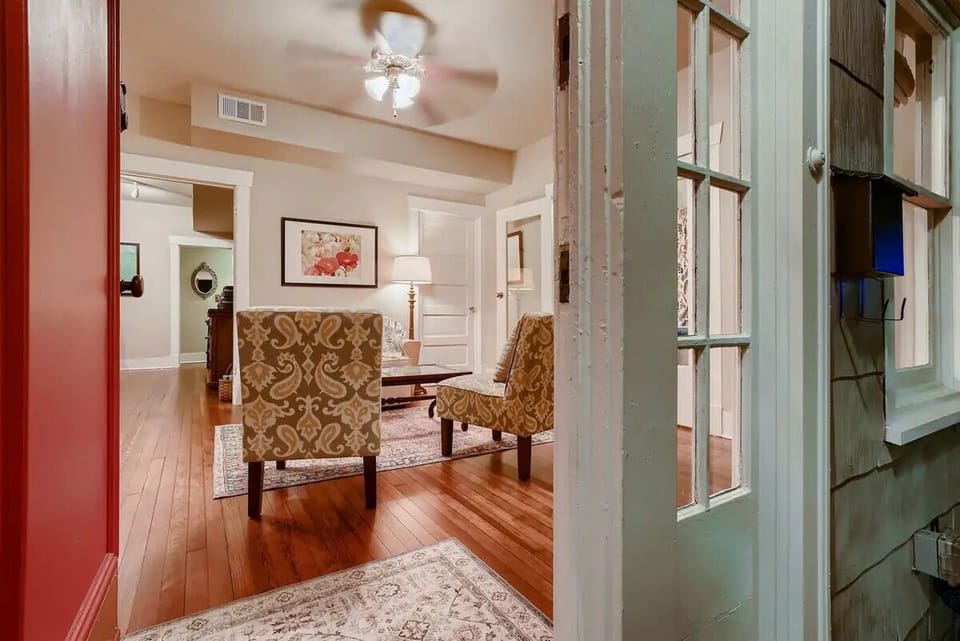 Enter into the lower level living room w/ original refinished red maple floors.