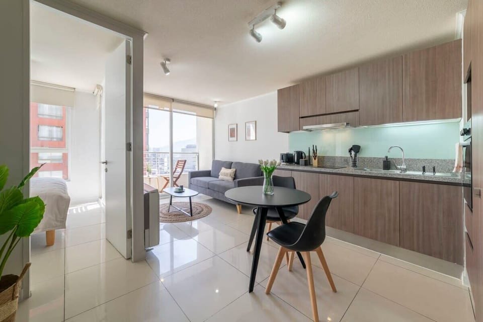 Experience urban living in this stylish open-plan space with a modern kitchen, cozy seating, and a stunning city view from the balcony.