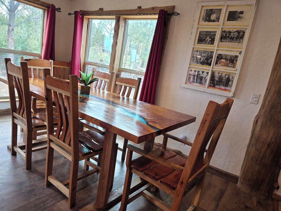 Live-edge dining table seats eight, framed by big windows with forest views.