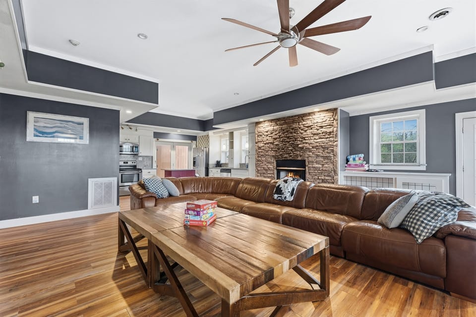 Huge basement and gathering space with massive couch, fireplace and air hockey, arcade and foosball