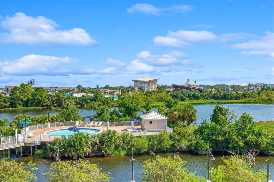 Relax by the outdoor pool surrounded by lush greenery and water views.