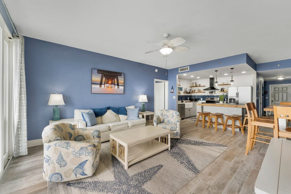 Open-concept living area with coastal-inspired decor and a fully equipped kitchen.