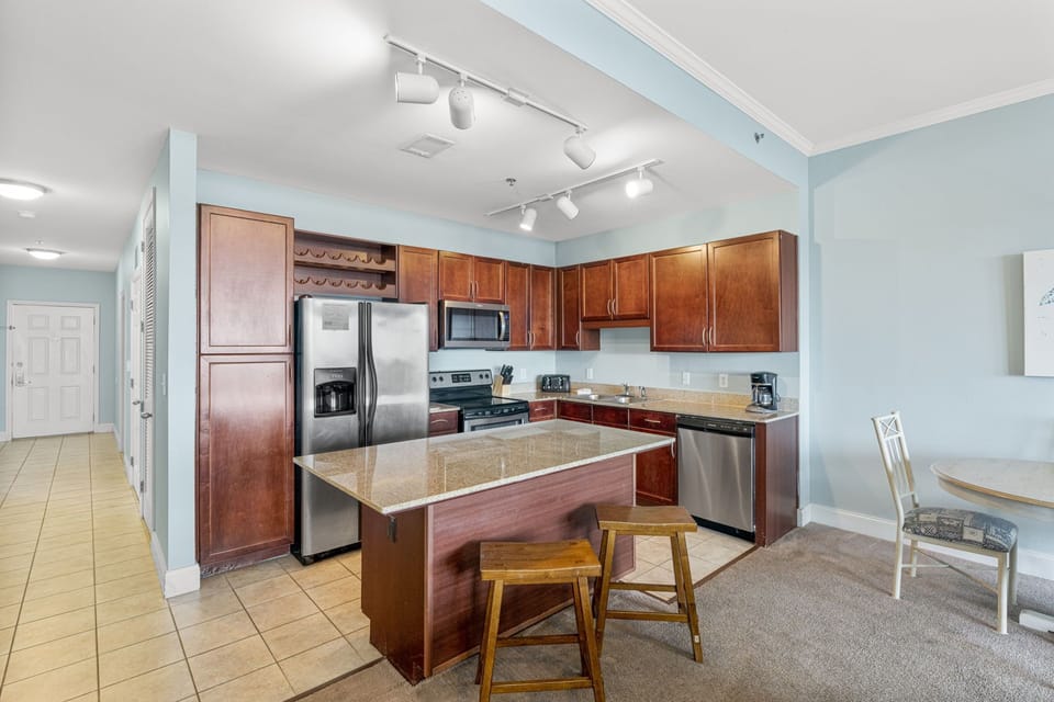 Modern kitchen with stainless steel appliances and a central island for casual dining.