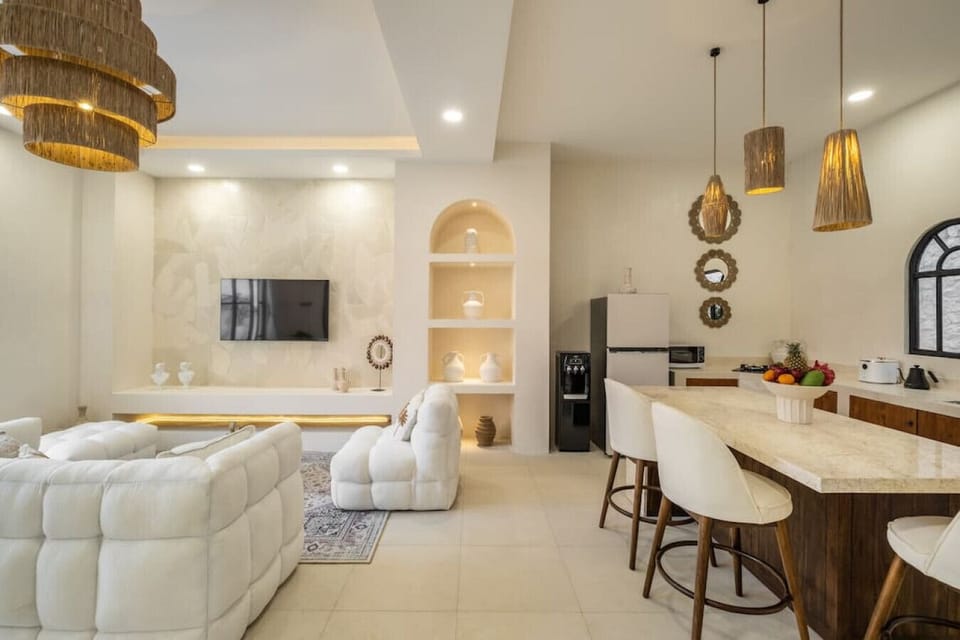 living area with an elegant dining space, featuring plush seating, chic decor, and dramatic arched doorways that enhance the flow of natural light.