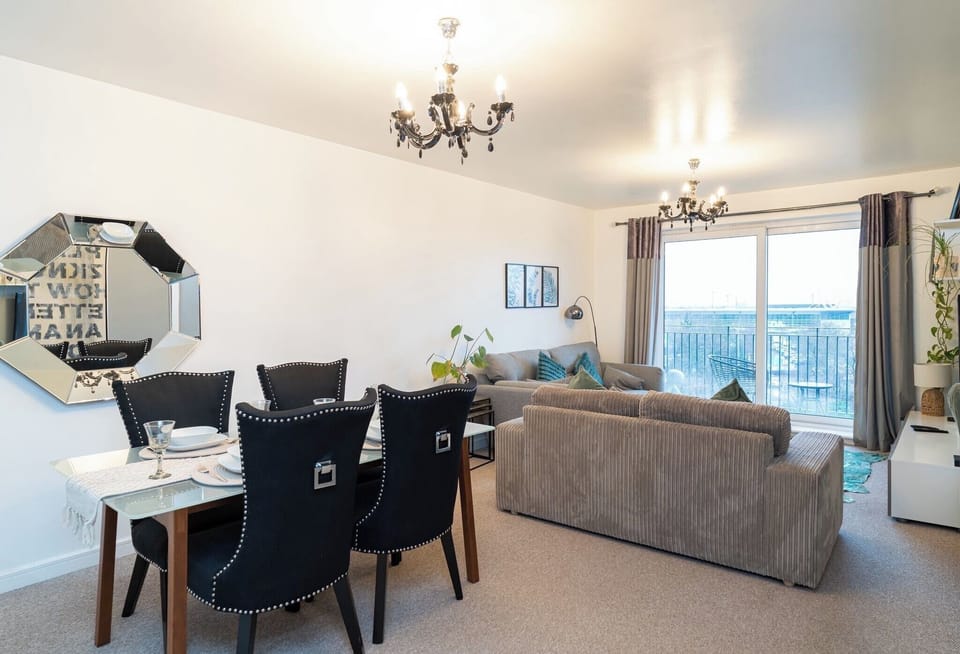 Our stylish living room offers a bright, comfortable space to unwind, featuring a cozy sofa, modern décor, and large doors opening onto the balcony with views of the Etihad Stadium. Relax with the Smart TV, enjoy plenty of natural light, and feel right at home in this warm, inviting space.