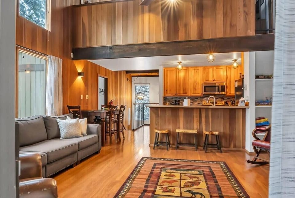 The view from the living room towards the kitchen. The main living space offers plenty of natural light and an abundance of seating, the perfect area for gathering!