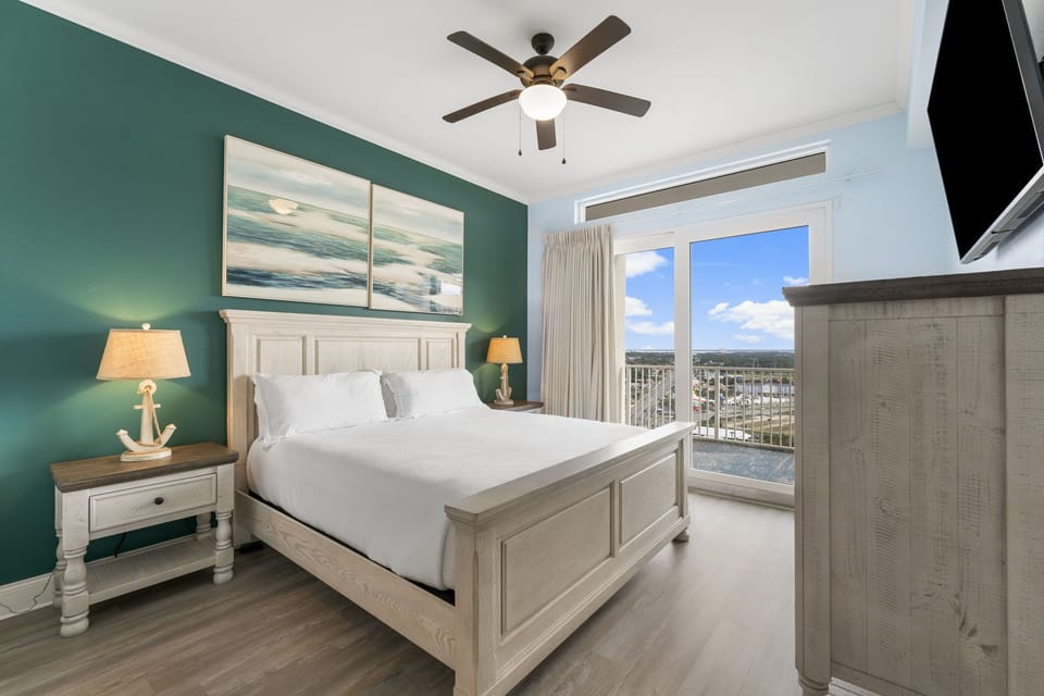 Relax in this coastal-inspired bedroom with balcony views and natural light.