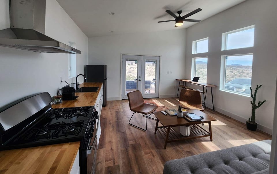 Full kitchen with stove, fridge, and utensils.