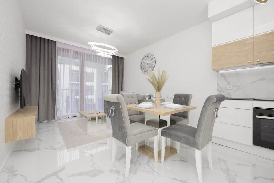 A closer look at the dining space, featuring a gray sofa, an elegant table setting, and decorative details enhancing the ambiance.

