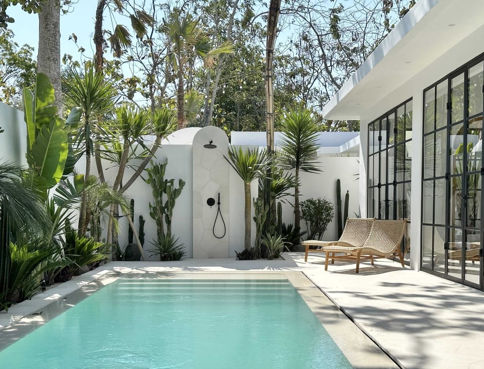 Large swimming pool with two sun lounges and an outdoor shower