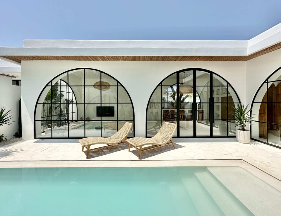 Outdoor area with a white swimming pool and lounge chairs