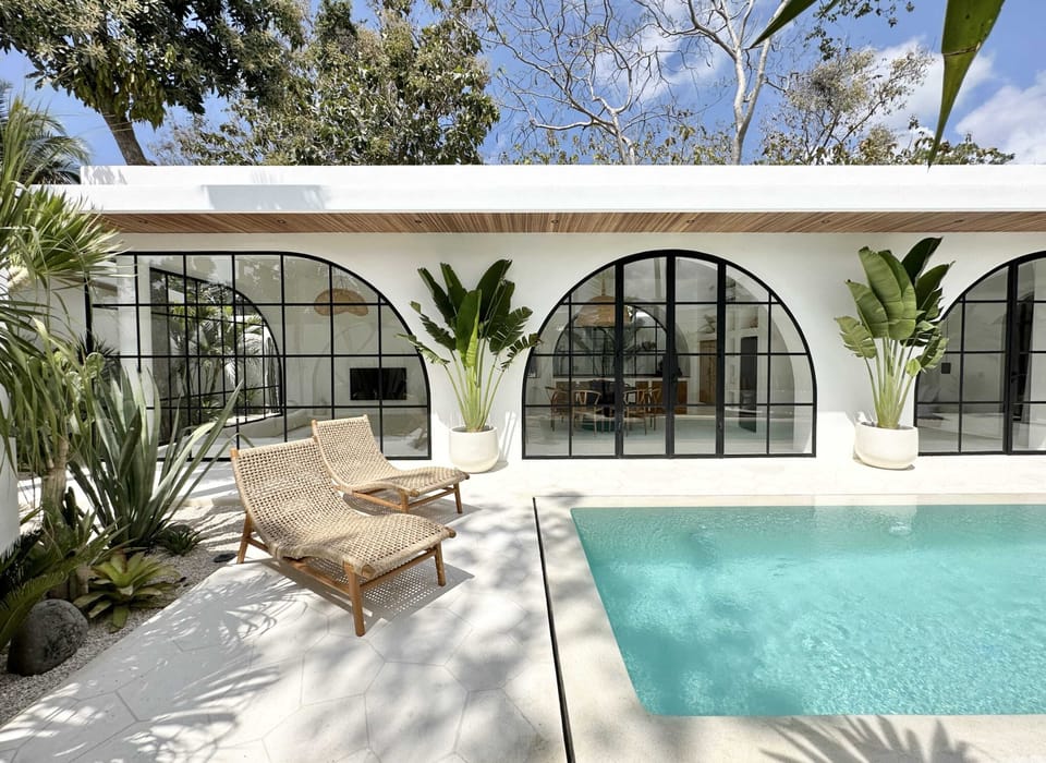 Two daybeds near the white swimming pool