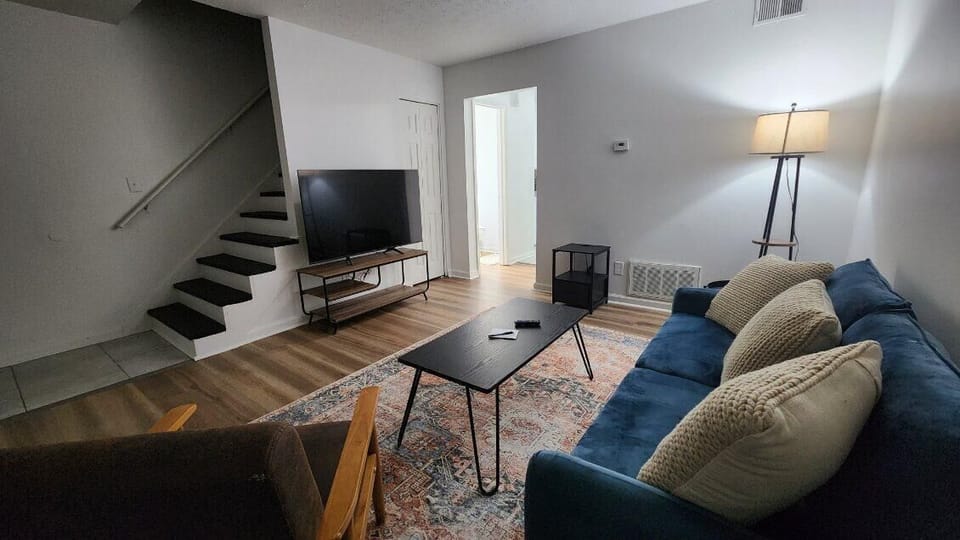 Living Room: The living room features a 55” flatscreen TV and a cozy couch, providing the perfect spot to keep you entertained after a long day out.