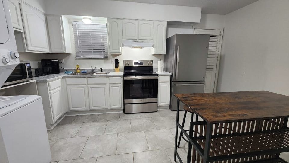 Kitchen: Our spacious kitchen is equipped with ample counter space, storage, stainless steel appliances, and an island table.